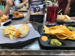 This place is called Cien Montaditos. They had 100 items on their menu. All really affordable. In this picture I had a small bocadilla, I forget what was in there - I think it was fried squid. I also got nachos and a tinto de verano, a summer wine which was kind of just like carbonated sangria. Which all cost me about 4 euros which is or was at the time, about 4 US dollars.